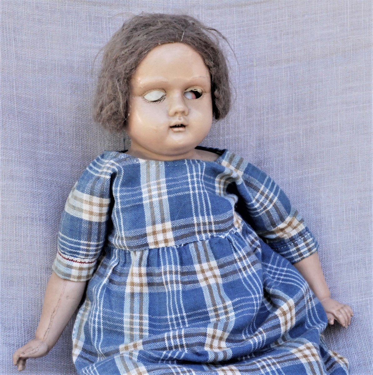 Dukken er en tysk "Skilpadde dukke", modell Åse. Tøykropp, celluloidhode og armer. Original kjole og klær. Brukt av giveren selv og hennes døtre