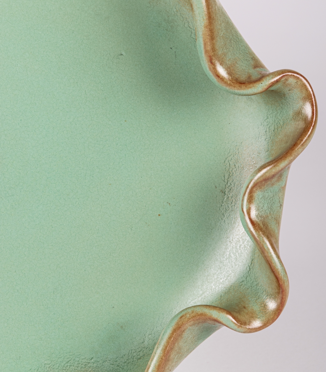 Skål i form av en fisk, glasyr 32; grön matt konstglasyr med bruna skiftningar, formgiven av Eva Jancke-Björk.