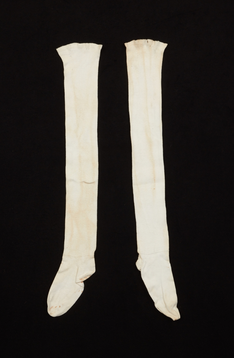 Ett par strumpor till en nationalromantisk dräkt, från 1900-talets början, med inspriration från Norra Ny i Värmland. Vita, hellånga maskinstickade bomullsstrumpor.
