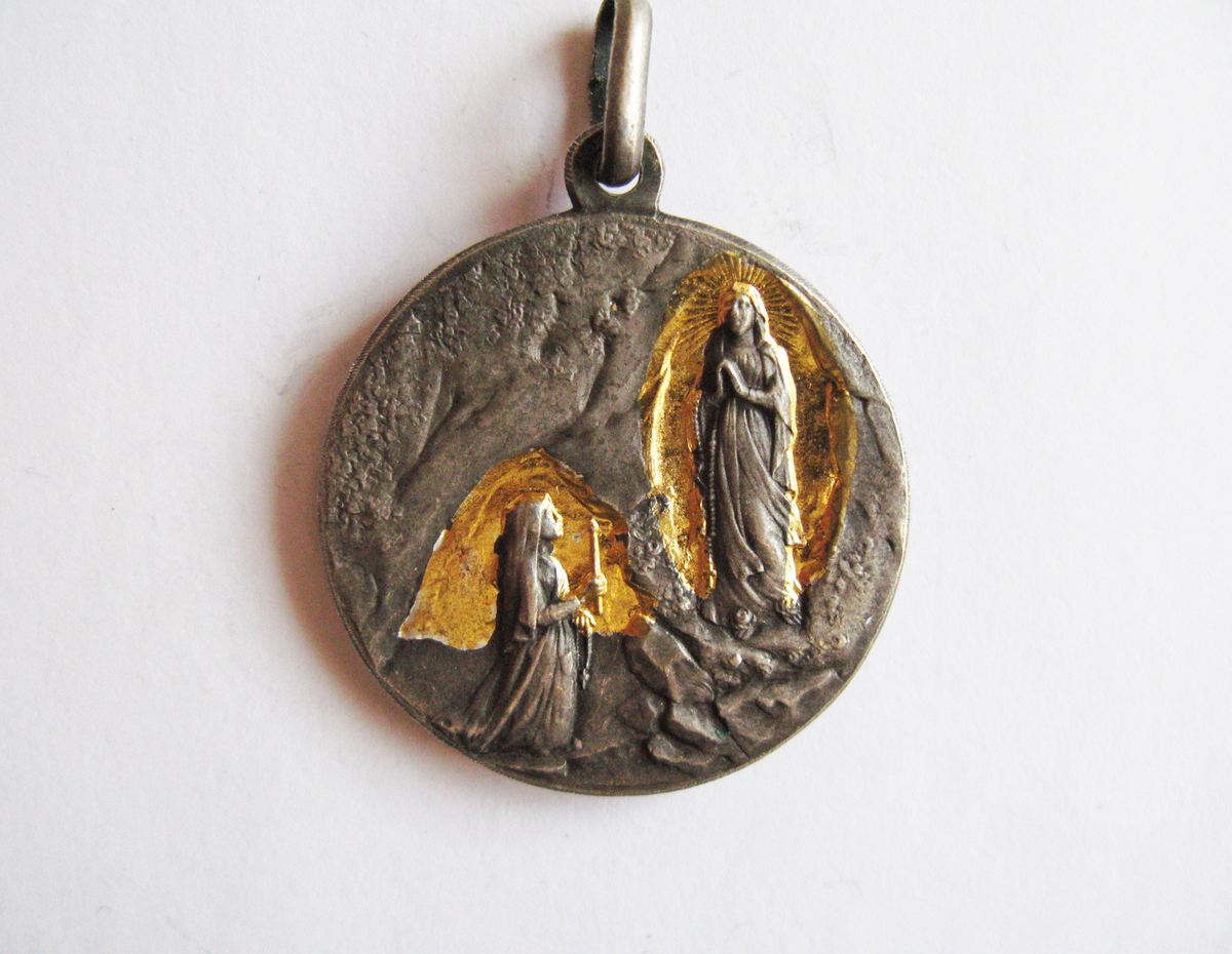Motiv advers: I rund medaljong i korsskjæringen på et malteserkors står et pasjonskors i stråleglans.

Motiv revers: Tekst om Maria-monogram.