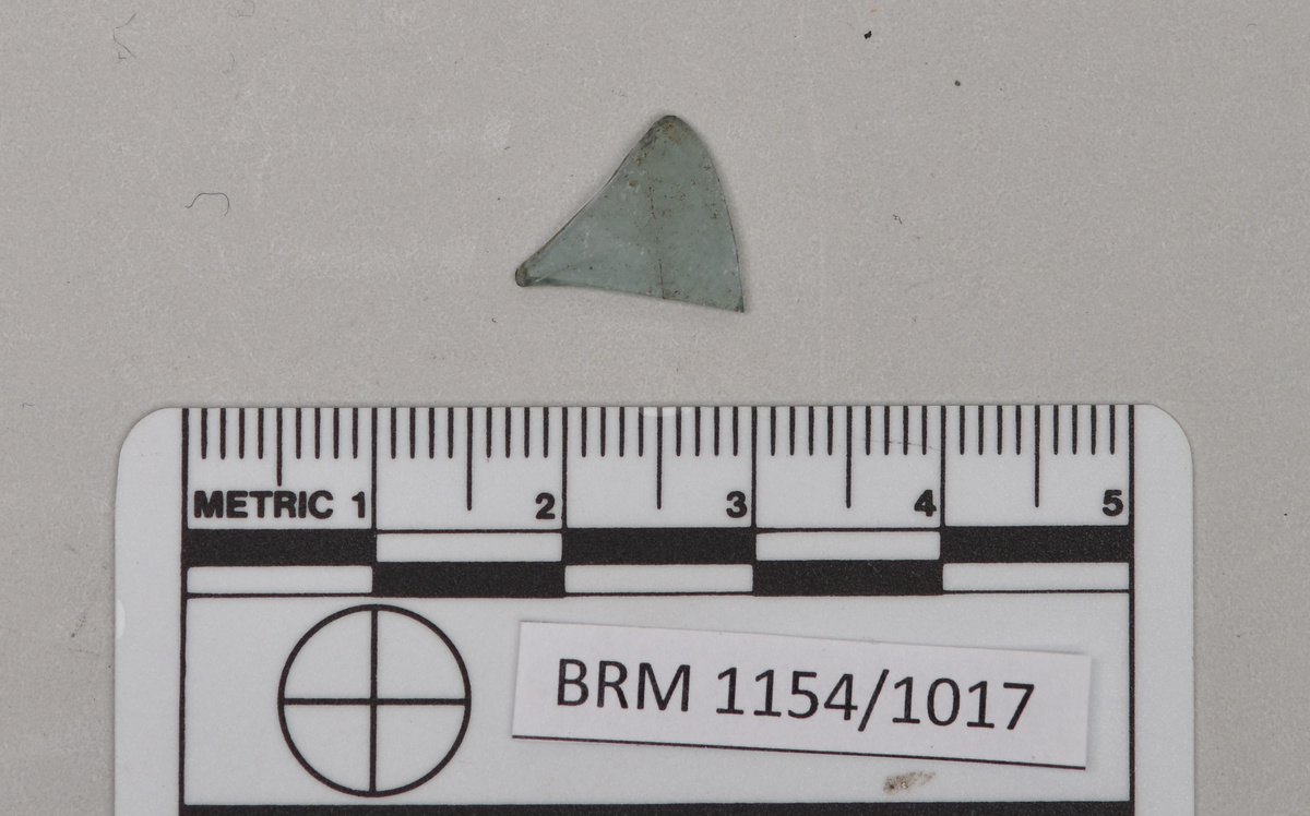 BRM 1154 Et tynt, lite og noe buet klokkeskår med en noe blågrønn farge