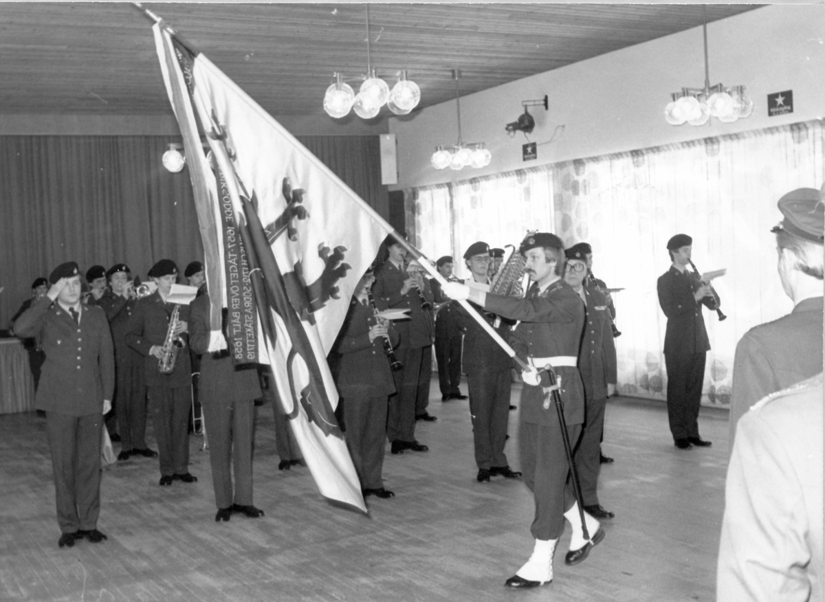 Arméns musikpluton genomför Krigsmans erinran i Soldathemmet, januari 1982.

Bild 1 Fanmarsch, löjtnant Bengt-Erik Larsson är fanförare.

Bild 2 Vid fanmarschen spelar plutonen och befälen hälsar fanan.