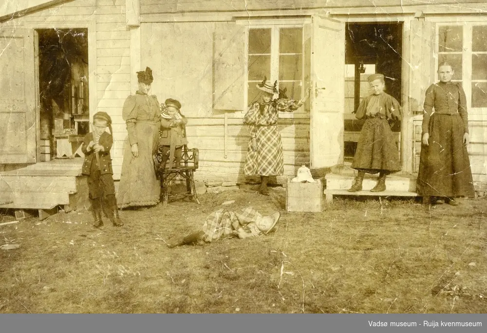 Gruppeportrett av familie på Barneng i Vadsø, 1895. Fra venstre Gunnar ( 8 år), mor Emma, Trygve (2 år), liggende Olaug (6 1/2 år), Magnhild (12 år), Sara Caspersen og Nina Wara( født Methi).