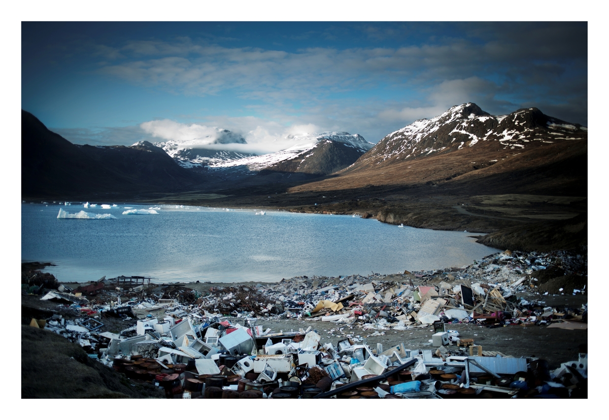 En søppelfylling i utkanten av byen Narsaq. I bakgrunnen er Kvanefjell, hvor selskaper håper å kunne finne sjeldne mineraler for utvinning. Fjellene rundt byen inneholder noen av verdens største forekomster av sjeldne mineraler. Inntil nylig har det vært umulig å lete og utvinne disse fordi 80 prosent av Grønland har vært dekket av is på opptil fire kilometer i tykkelse.
