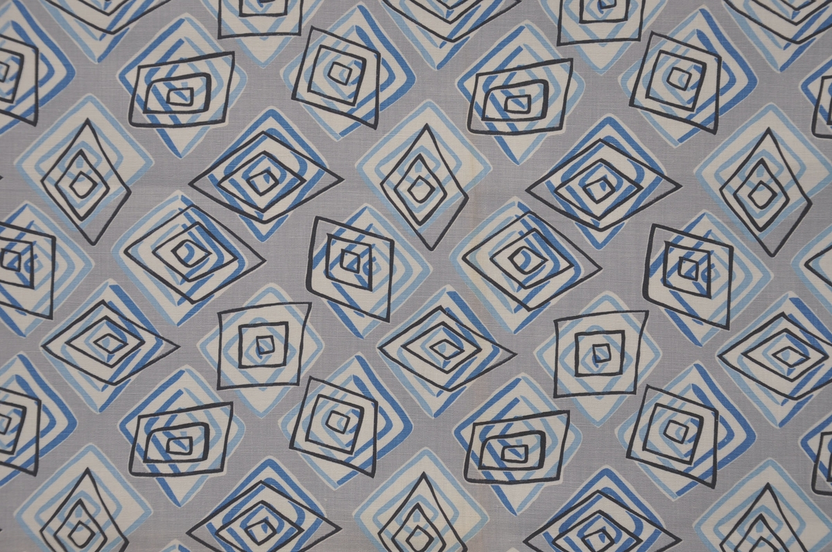 Bomullstyg, början av 1960-talet.
Klänningstyg på 75 cm bredd, kvalitet Mariska. BW2193, dess. 3997-1.
Tryckt mönster med kvadratiska figurer i svart och blått mot grå botten. Den svarta formen är försatt mot den blå.
Rapport 20 x19,2 cm.
Tryckfärger 4.