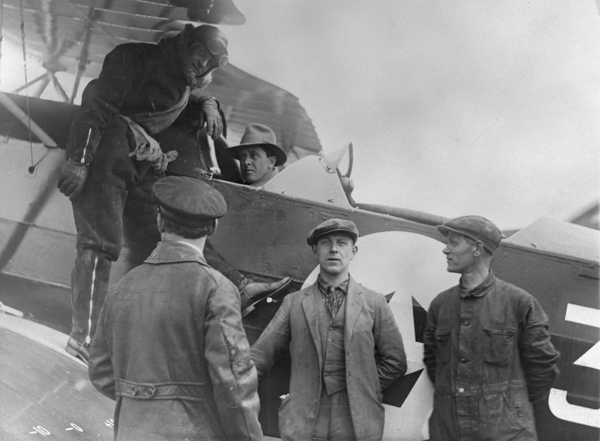 Motoringenjör H. Larsson motorkör flygplan S 6, Fokker C. V. medan kapten Einar Lundborg väntar på vingen, 1928. I mitten framför flygplanet står montör David Weibahr.
