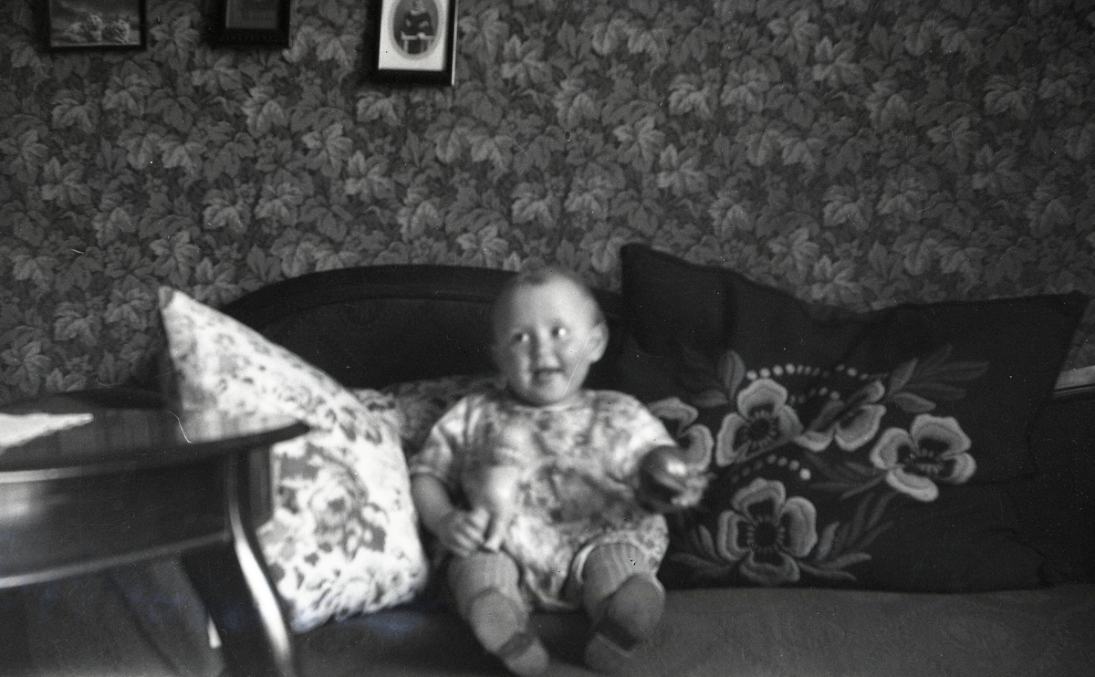 Tordis Terjesen som lite barn i sofaen heime i Porsgrunn.