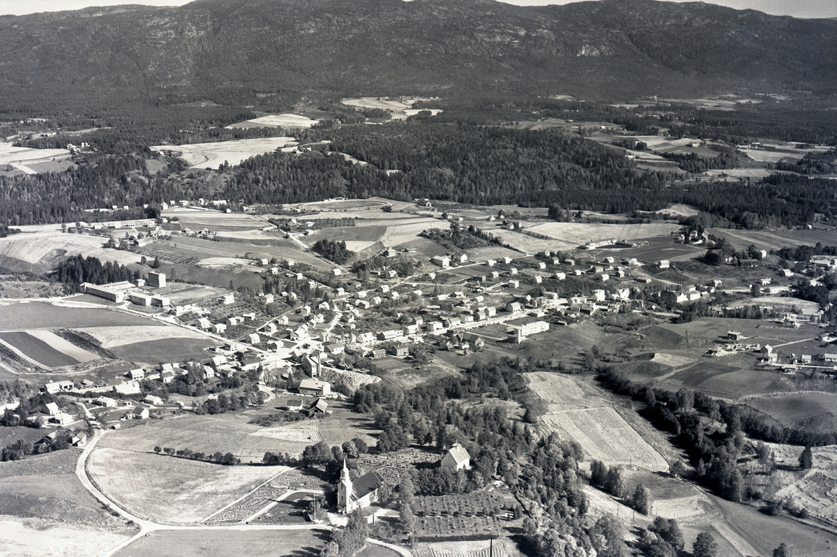 Flyfoto av Bøhaugen med kyrkjene og Bø sentrum frå vest.  Tatt 21. september 1963.
