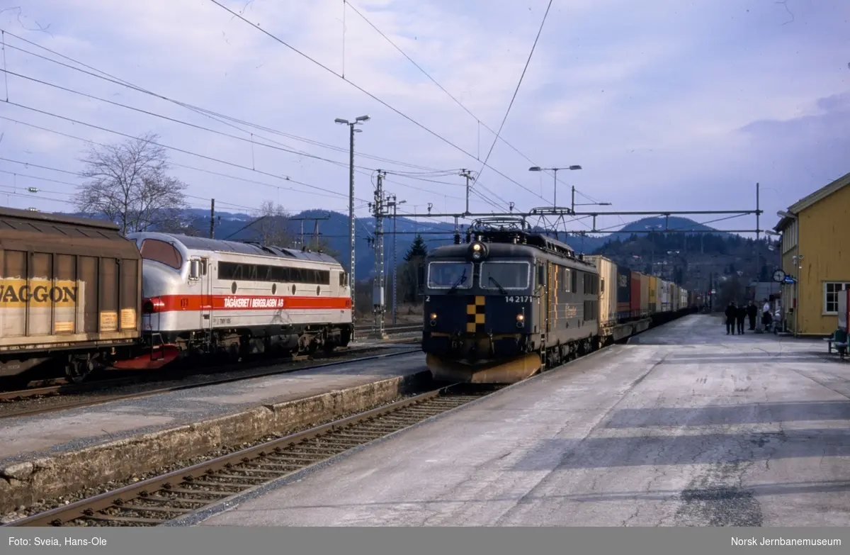 Kryssing mellom godstog (papirtog) fra Ranheim, tog 8738, trukket av TÅGAB diesellok TMY 105, og godstog til Trondheim, tog 5721, trukket av elektrisk lokomotiv El 14 2171 på Støren stasjon