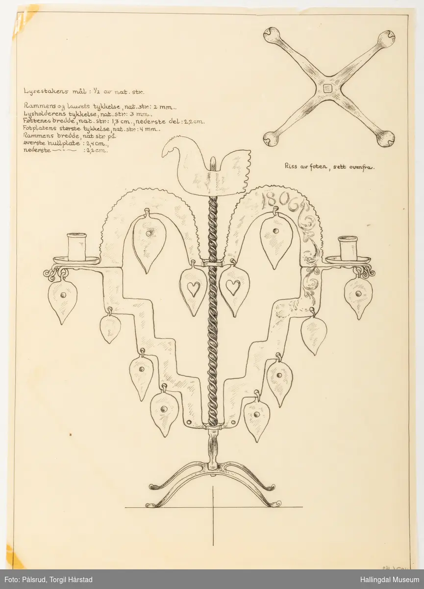 Hanestaken er hjerteformet med bærestang i midten, på toppen av stangen er det plasset en hanefigur. Øverste del av hjerteformen har ruglete kanter, begge sidene har et dråpeformet påheng. To dråpeformede påheng med hjerteformet hull på hver side er plassert nærmere midtstangen. Staken har to lyseholdere, en på hver side av hjerteformen, begge har dråpeformet påheng under. Nedre del av hjerteformen har en trappformet utforming der det er montert 6 dråpeformet påheng, 3 på hver side. Midtstangen er litt bredere nederst og ender i fire bredere stetter. Øverst til venstre er det skrevet inn mål, øverst på høyre side er det et riss av stettene. Skissert inn på hjerteformen: 1806 og rosemaling. stetten står på et kryss. Tegningen er rammet inn med en enkel linje.