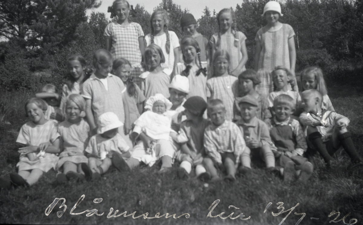 Astrid Margrethe Terjesen med dotter Tordis og ei rekkje jenter rundt.  Tatt 26.7.1926