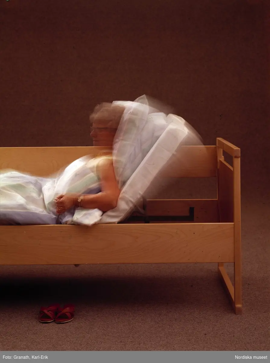 Kvinna i säng med reglerbar botten.