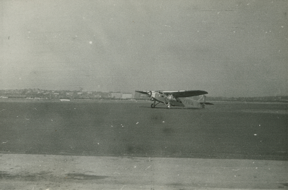 Fotografi från låda märkt Bernt Balchen. Balchen var norsk-amerikansk flygare, polarforskare och militär. Flygplanet är eventuellt tillhörande familjen Ford Trimotor och ses här på ett flygfält.