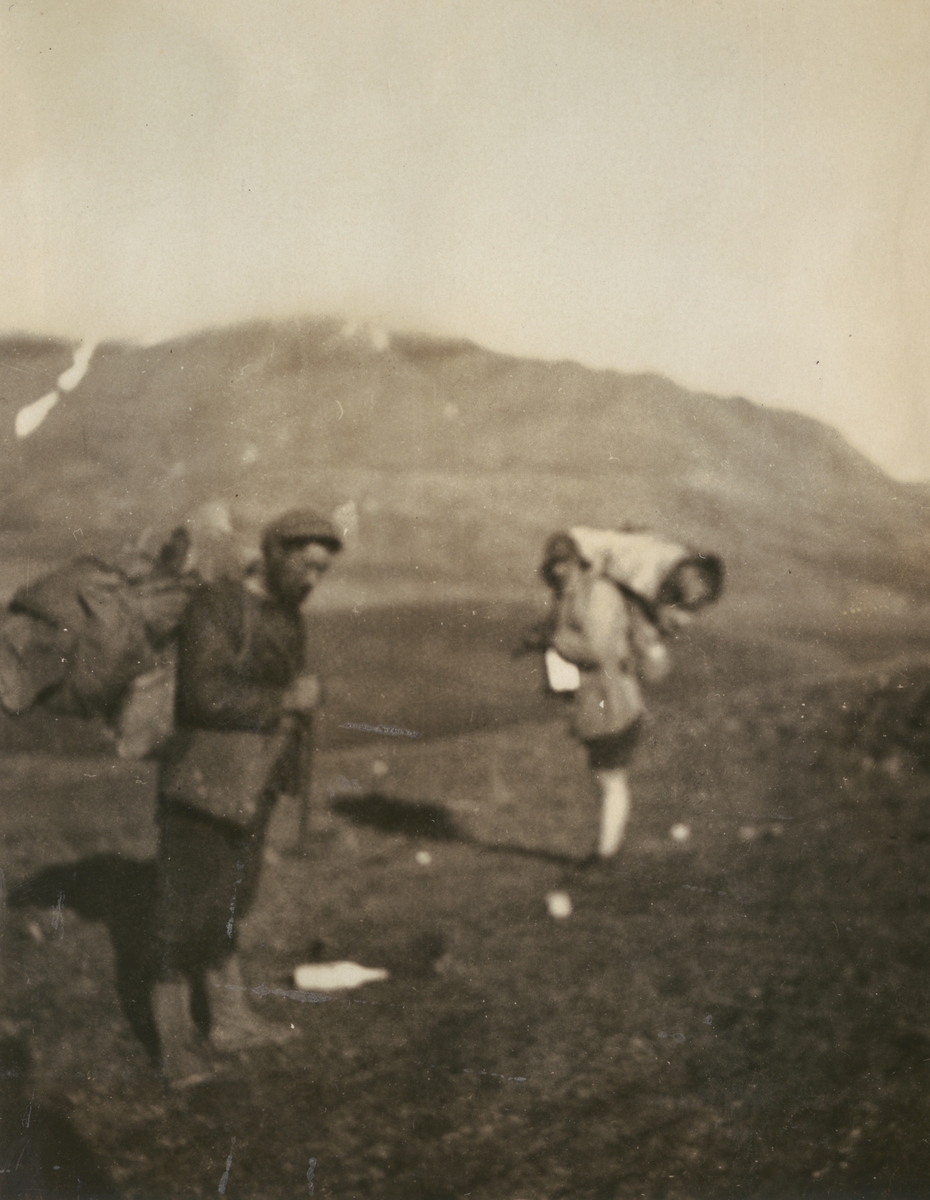Fotografi från expedition till Sveagruvan. Motiv av två expeditionsdeltagare som vandrar i bergslandskap med packning på ryggen.
