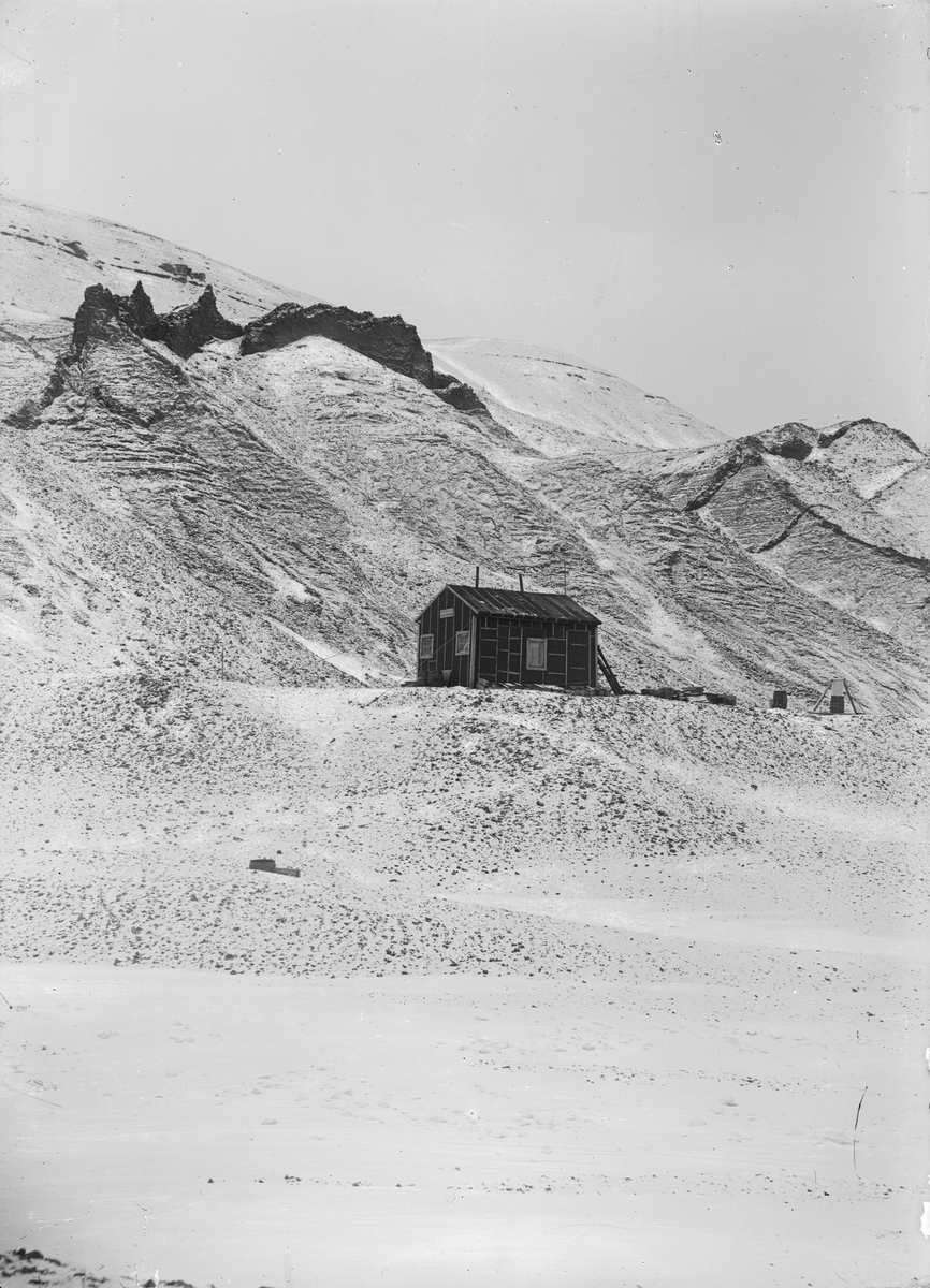 Fotografi från undsättningsexpeditionen med fartyget Uruguay 1903.  Motiv av litet hus i snötäckt bergslandskap.
