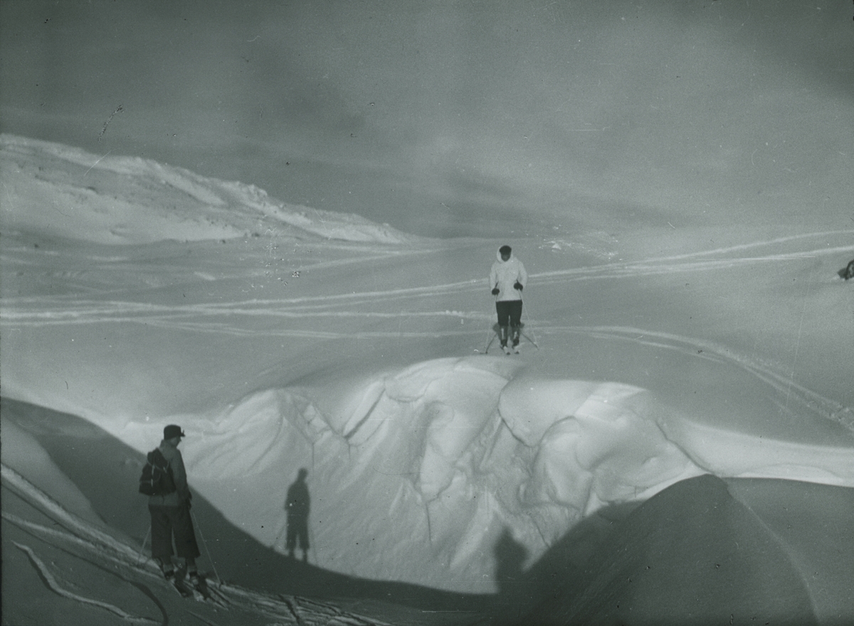 Fotografi från expedition till Spetsbergen. Motiv av två män på skidor i snölandskap.