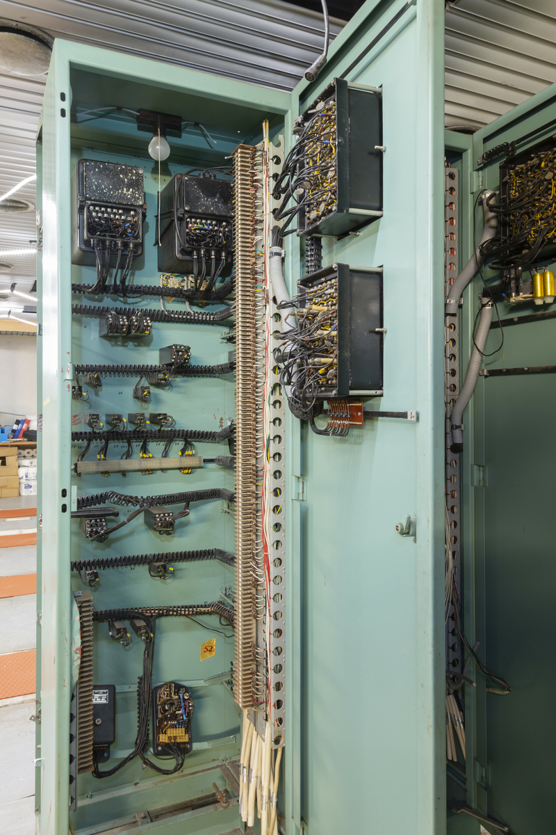 Skåp (höger del) till system som visar sprickdetektering. Hör till TM48444:1 Skåp (vänster). Text överst: "ERINGSSYSTEM", nedre högra hörn "04"
Stativ i grönlackad plåt innehållande elektronik. Panel med vred, instrument och lampor samt färgmarkering av system i kärnkraftverk.