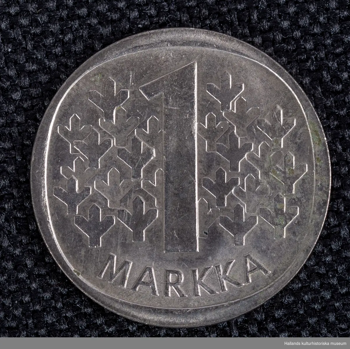 Finskt mynt av kopparnickel. 1 markkaPräglingsår 1971. Åtsida: Präglingsår, riksvapen samt texten: "SUOMEN TASAVAKTA" (republiken finland)Frånsida: Valör samt 22 st symboler (bild). 