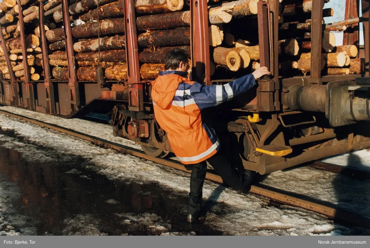 Lokomotivfører Tor Bjerke kontrollerer bremsene på fullastet tømmervogn litra Rps på Eina stasjon