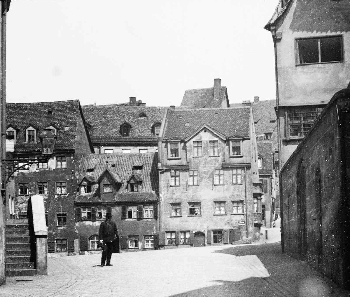 Skioptikonbild med motiv av man på gata i Nürnberg.
Bilden har förvarats i kartong märkt: Nürnberg 1901. VIII.
Bilden är eventuellt tagen vid Hübnersplatz och Vordere Fischergasse med utsikt mot norr.