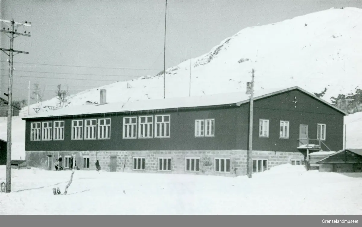 Realskolen i Kirkenes etter krigen 1946-1956. Brakka hadde fire klasserom. Vinduene til høyre er rektorboligen. Bildet er tatt i 1949. 