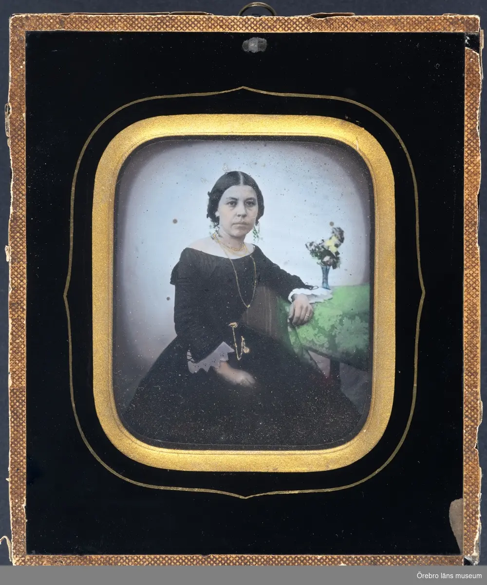 En kvinna.
Porträtt av Augusta Matilda Hasselström, född Lindberg, som förlovad.