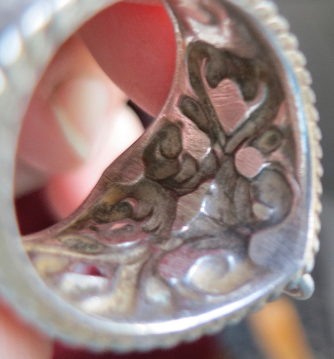 Bred ring med inpressad dekor, har ursprungligen haft 7 mindre ringar som dekoration. Finns också med 9 ringar.