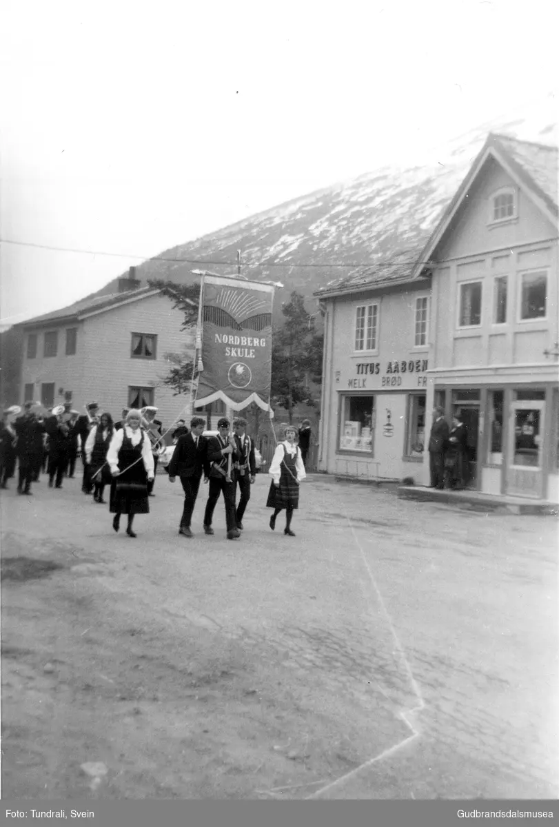 17. mai-toget frå Nordberg skule passerer butikken til Titus Åboen på veg til Nordberg kyrkje