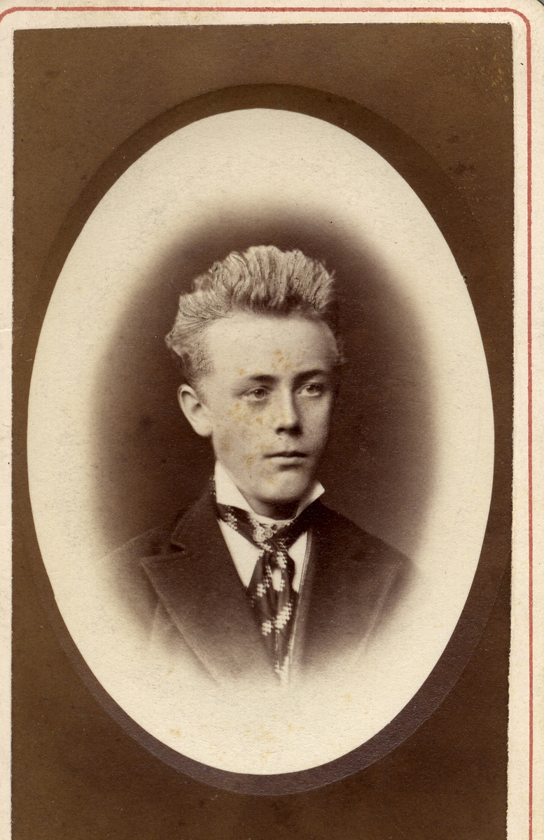 Mannsportrett. Ung mann med blondt hår og slips, i oval ramme.