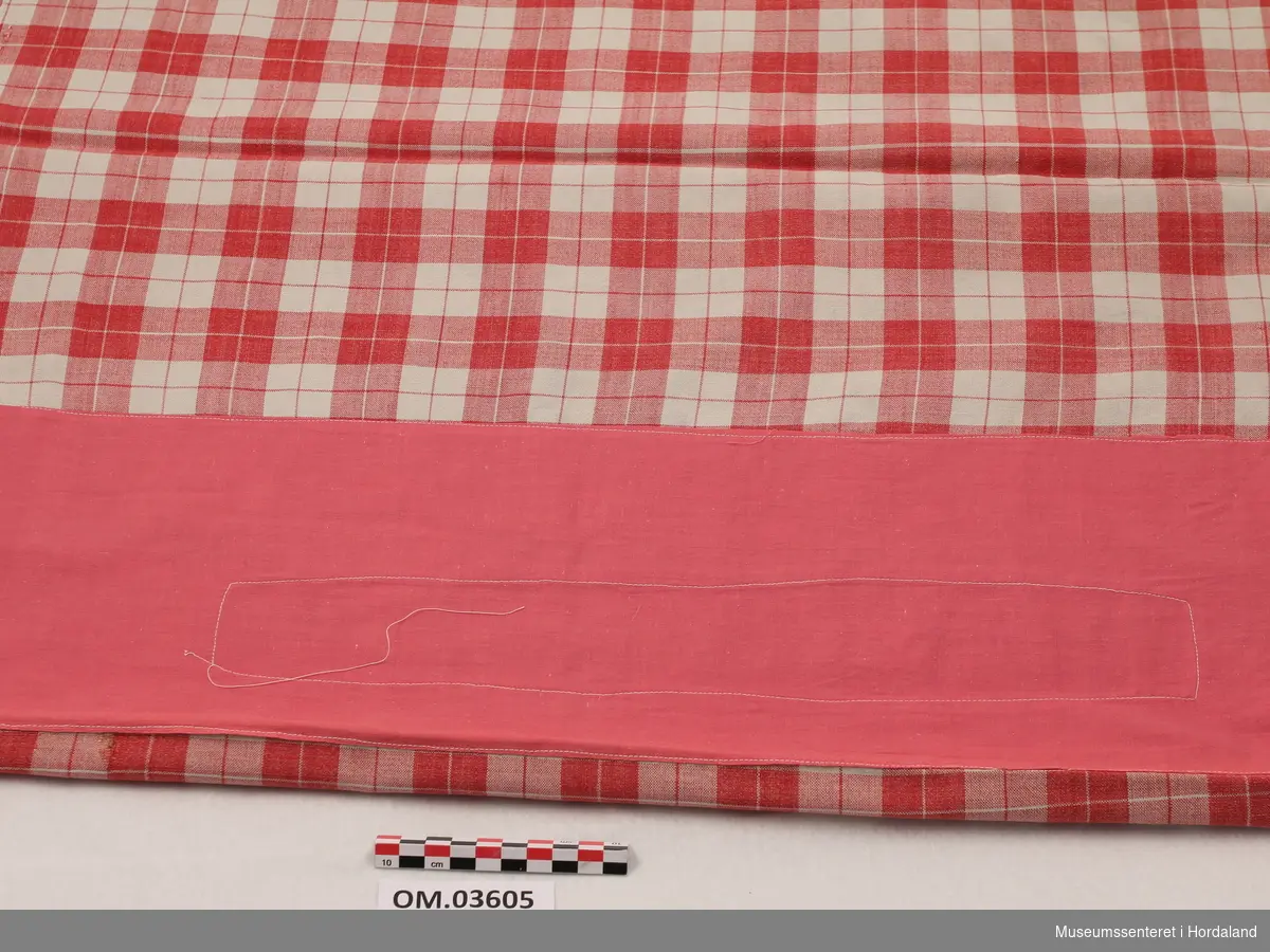 Rødt og hvitt rutete sengetøy med kvadratisk form.