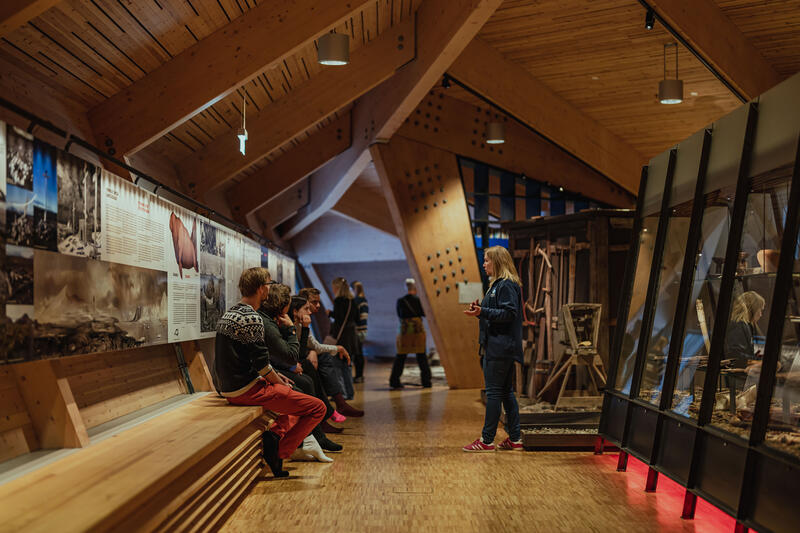 Bildet viser en liten gruppe som er sammen med en formidler i museet.