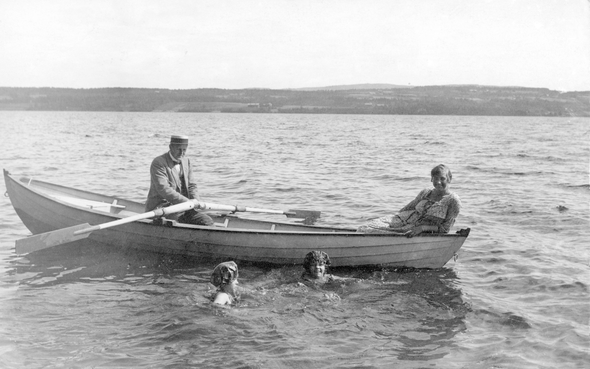 Robåt på Mjøsa. Leif Castberg og Mosse Castberg i båten. I vannet: Inga Bruusgaard til venstre og Gerd Castberg gift Oftedal til høyre. Båten er en mjøsbåt laget av Karl Antonsen med oppnavn «Brynkopp». Båten, en «Ka’l-båt», var en god mjøsbåt.