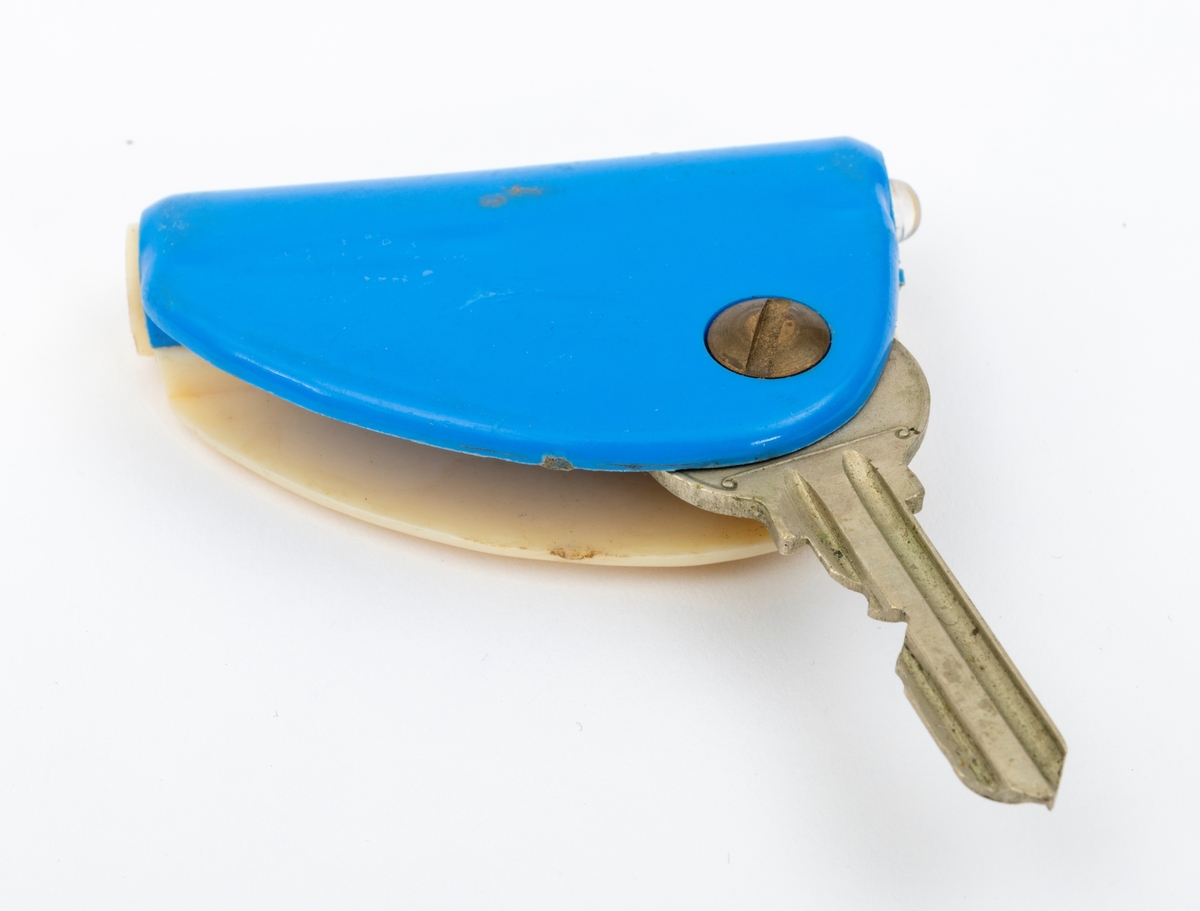 Nøkkel i blå og hvit plastholder med innebygd lommelykt.