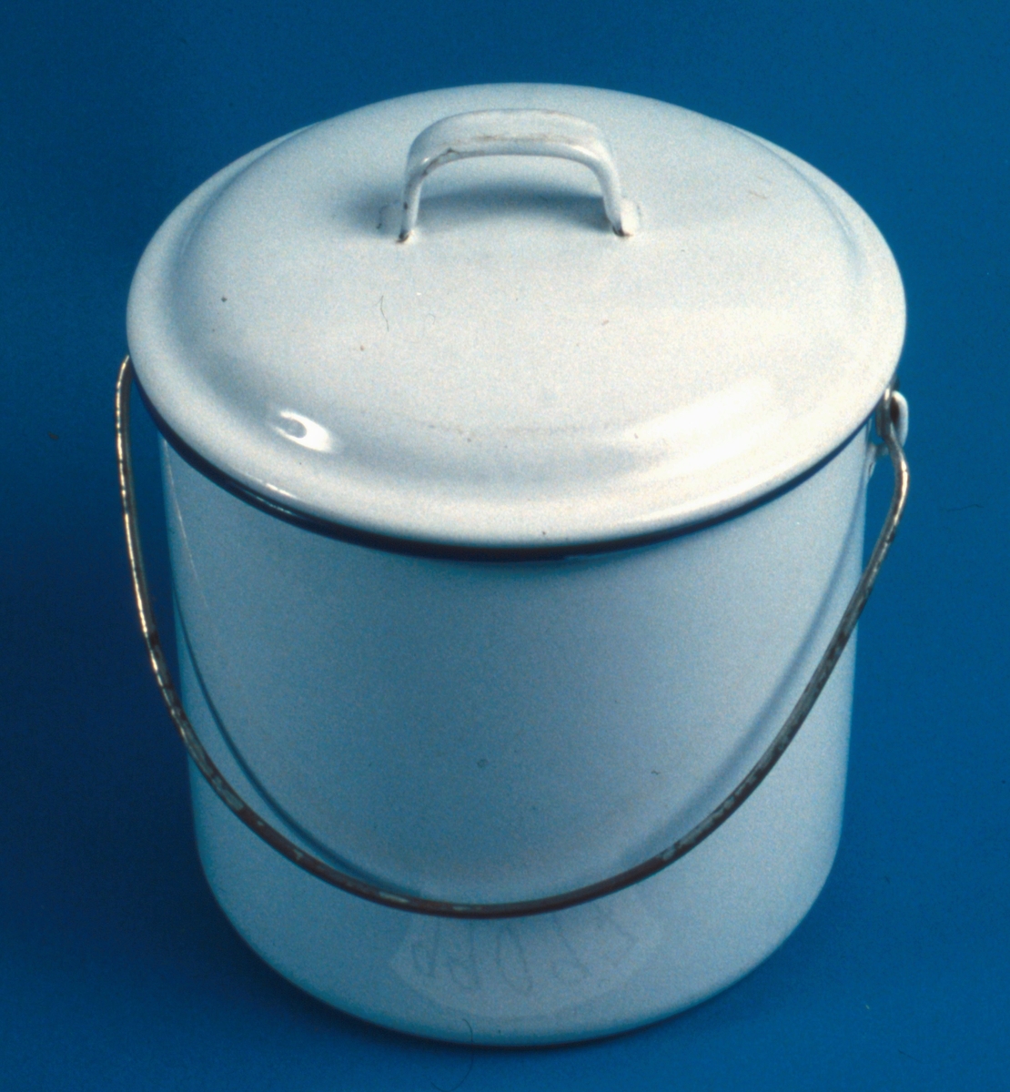 Cylinderformad spann med lock. Tvärgrepp av stål, vit med blå mynningskant.