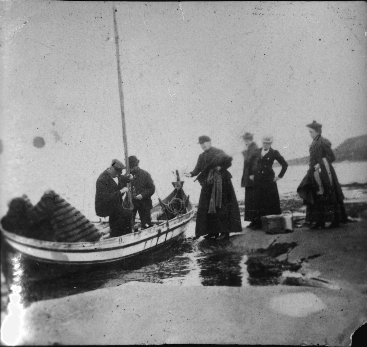 Gruppebilde av fire kvinner og to menn ved nordlandsbåt i fjæra på Elde i Kvæfjord.
