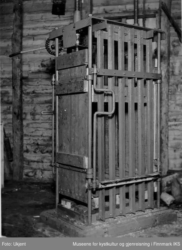 Bildet viser en lukket og tomt tørrfiskpresse. Bildet ble trolig tatt da familie Normann fra Melkøya i Finnmark ønsket å kjøpe en tørrfiskpresse til eget bruk på 1930-tallet. 