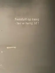 Det står "Trekkfullt og trasig -- førr ei herlig tid!" på veggen.