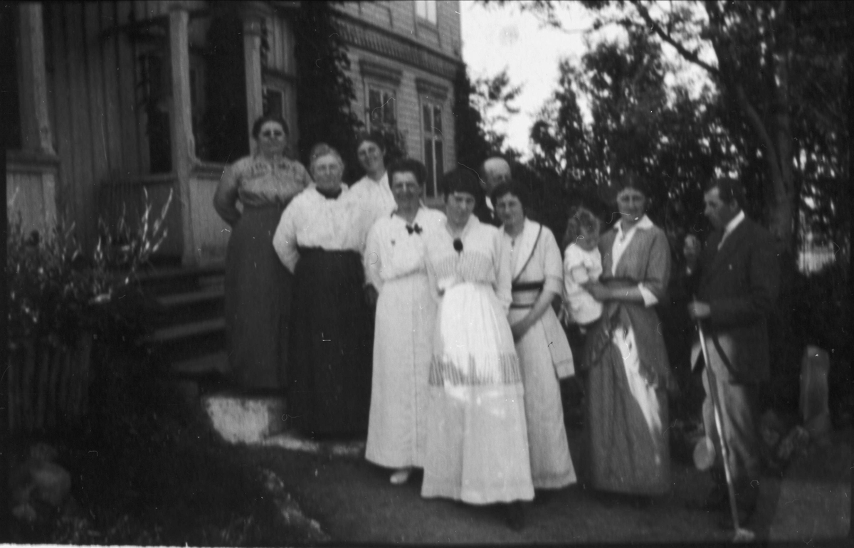 Gruppebilde av familie stående på trappa til Kaarbøgården.