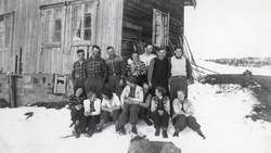 Gruppebilde tatt i forbindelse med en skitur. Et gammelt hus