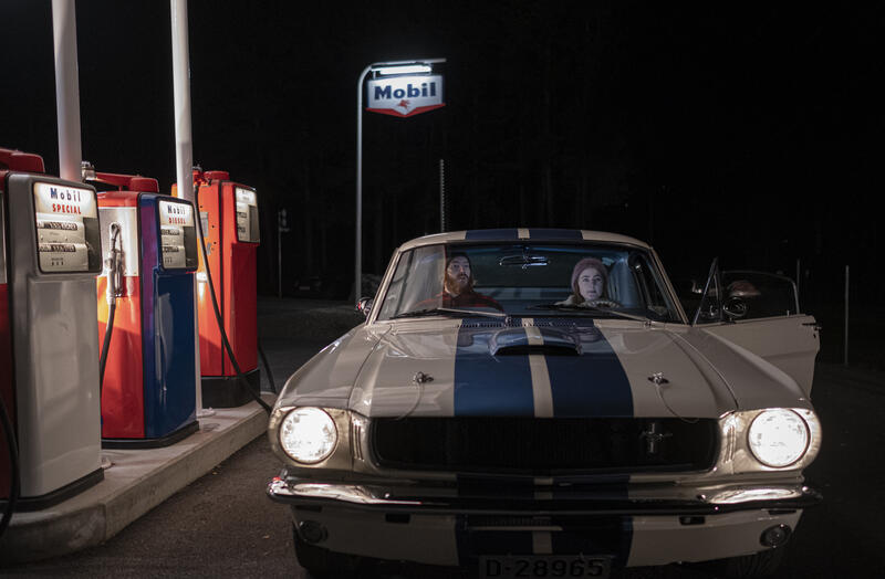 Bildet viser en bil utenfor en bensinstasjon under en filminnspilling