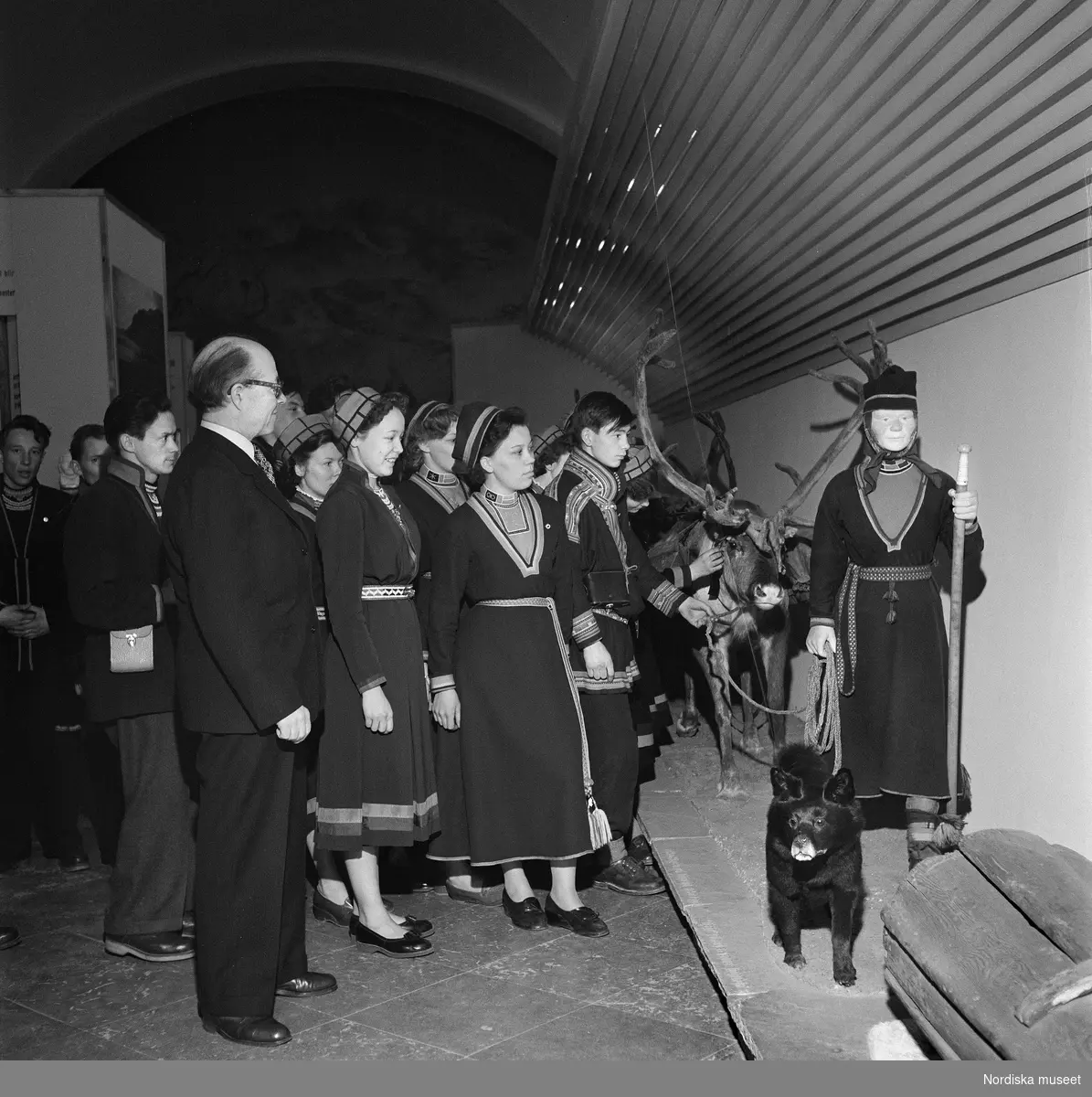 Ernst Manker visar utställning under för elever från Samernas Folkhögskola i Jokkmokk vid ett studiebesök på Nordiska Museets samiska avdelning 28/4 1954.