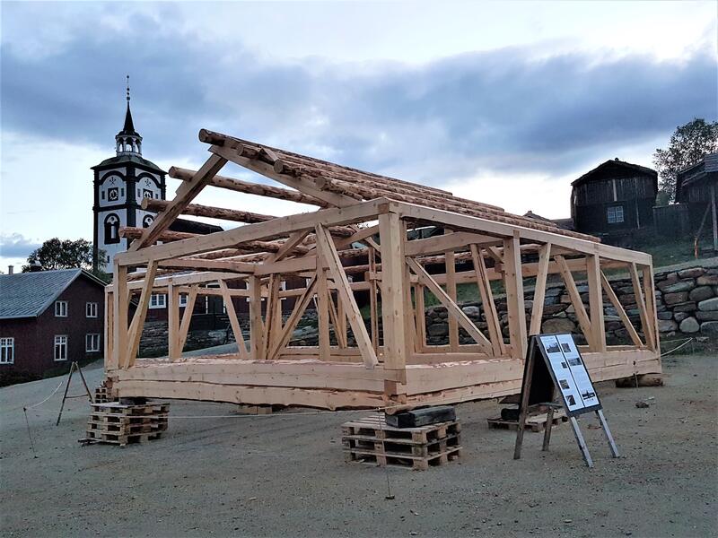 Bildet viser en tømret reisverks-konstruksjon på Malmplassen med røroskirka i bakgrunnen.