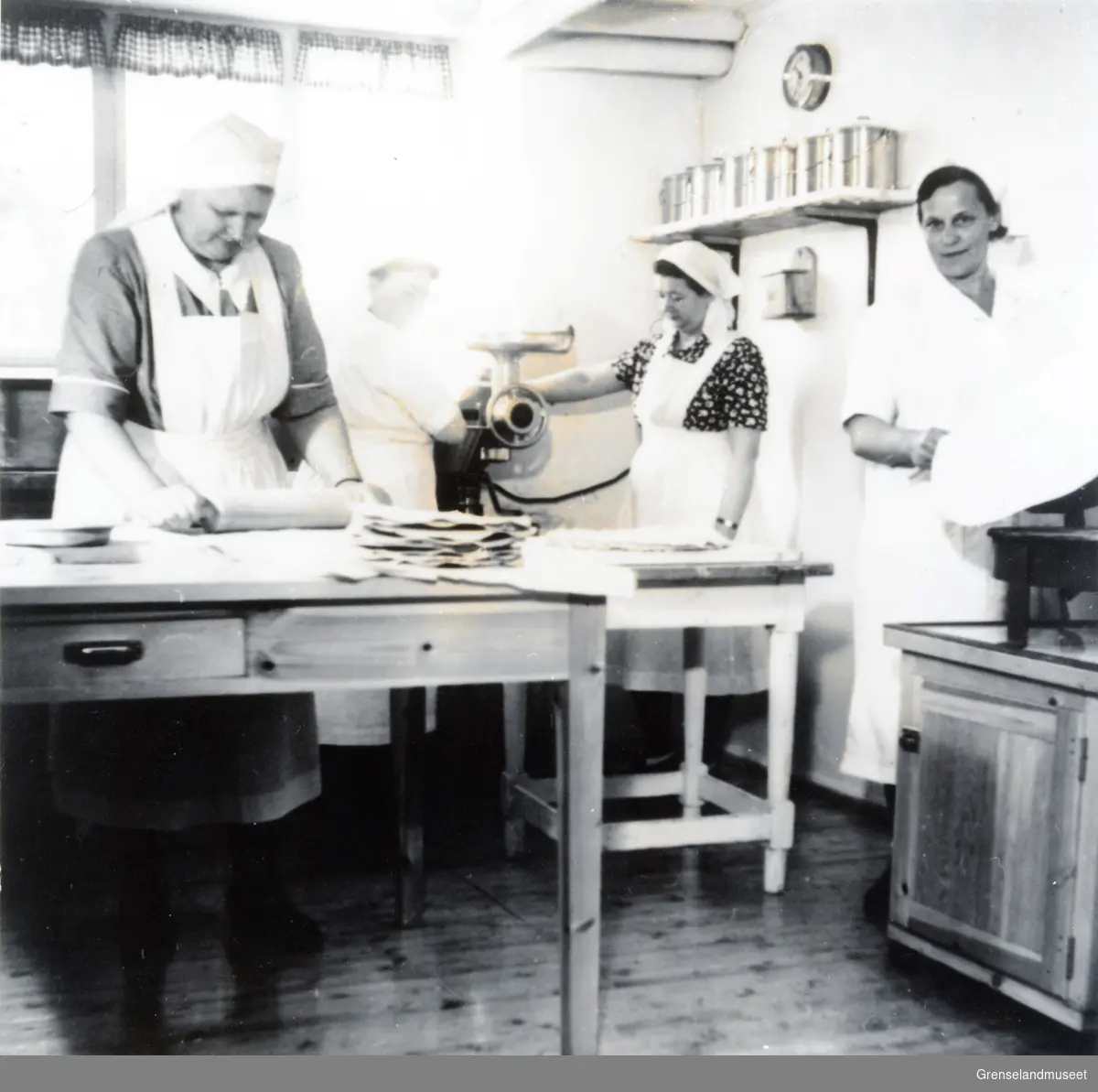 Fire personer arbeider på kjøkkenet på skolen på Skogfoss. 