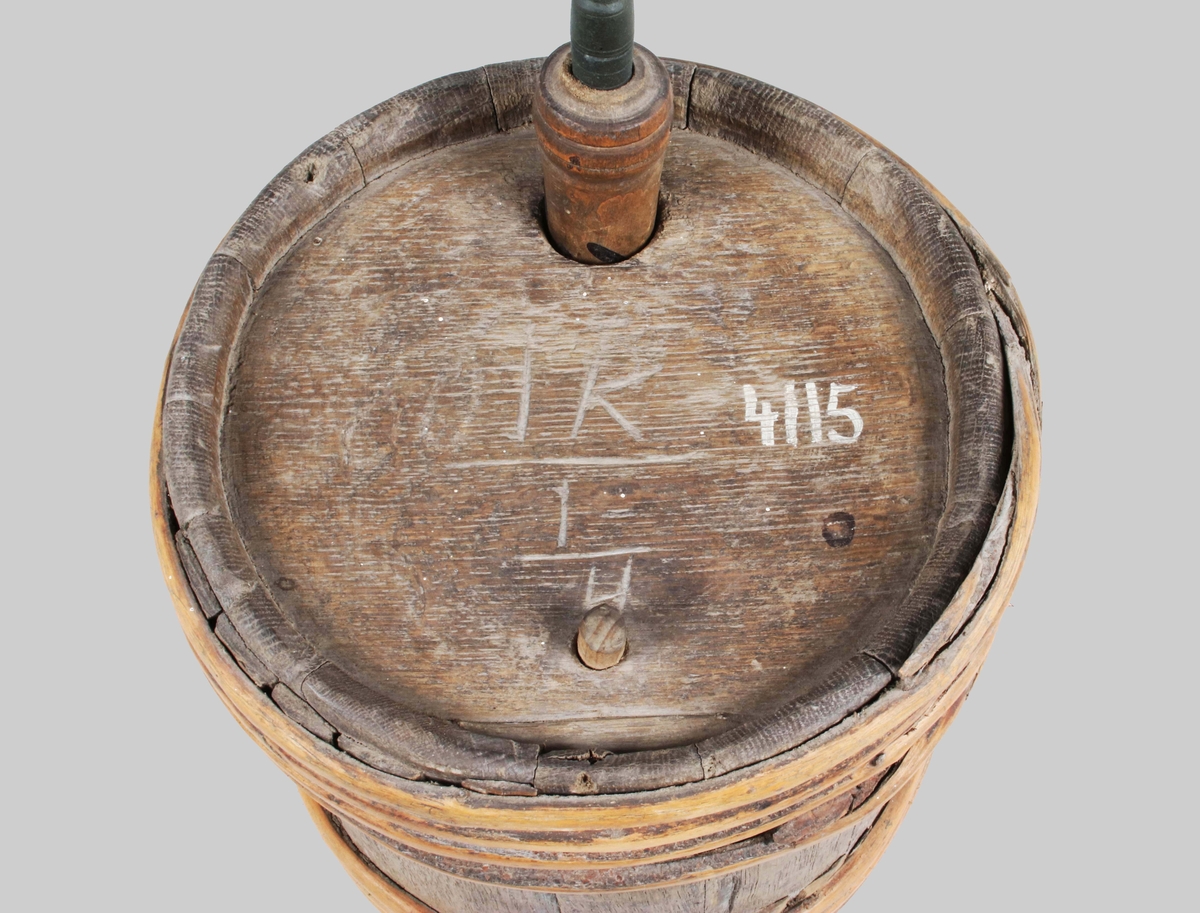 Cylindriskt laggat kärl med 7 granvidjor. 2 hål på ovansidan, det mindre med liten träplugg. Rymd inskuret på ovansidan, initialer och årtal i botten: "SJS 1854 / IK 1/4".
