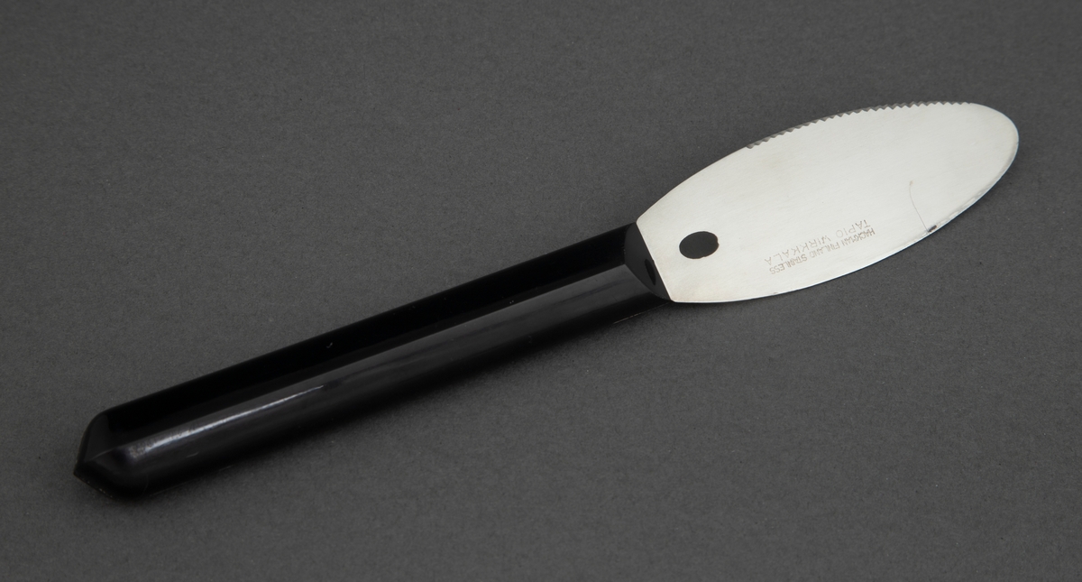 Smørkniv i rustfritt stål med svart, kantete nylonskaft. Skaftet er festet rett til bladet. Utstanset oval nederst i knivbladet for oppheng.