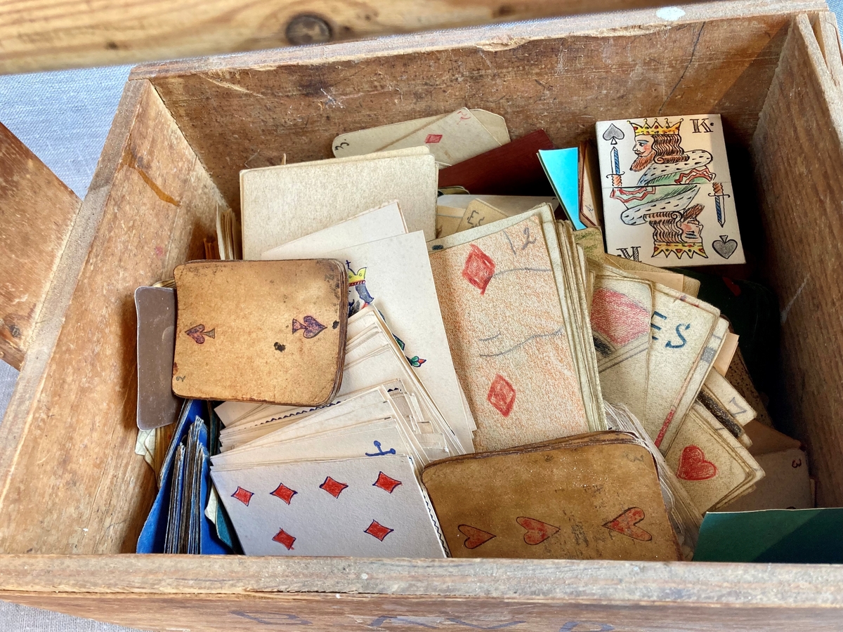 Trekasse med håndtak merket "b. avd". Kassen inneholder mange hjemmelgede, håndtegnede kortstokker.