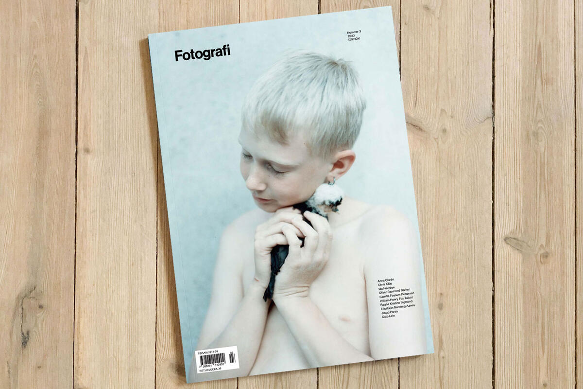 Forsiden av Fotografi nummer 2 2023 har bile av en gutt som holder en fugl. Bildet er tatt av Anna Clarén.