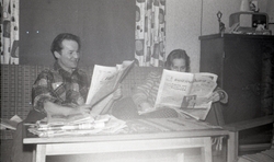 Odd Jarl Askvik og Margit Askvik leser i aviser i stua i bol
