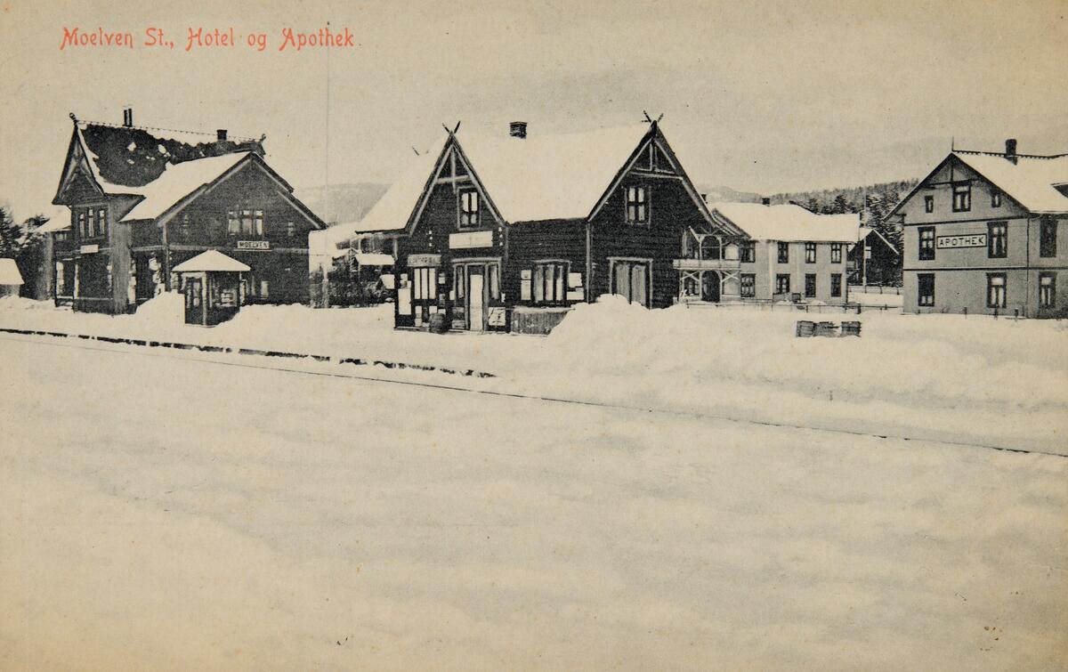 Postkort, Ringsaker, Moelv stasjon, navnet Moelven stasjon ble brukt fra 1894 til 1. september 1922, Narvesenkiosk på perrongen, pakkhus, Moelven Hotell, apotek, vinter.