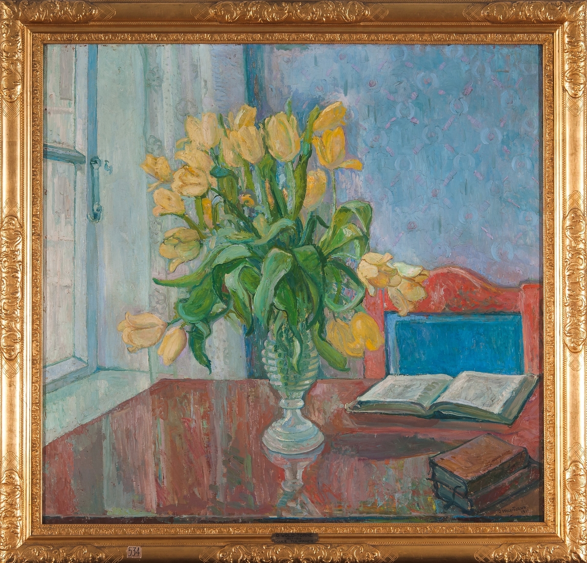 Bord med bøker og en vase tulipaner.
